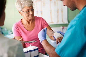 An older woman getting prepared to have her blood drawn