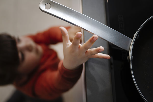Child reaching for pan
