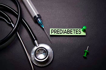 A stethoscope and needle next to a slip of paper saying Prediabetes