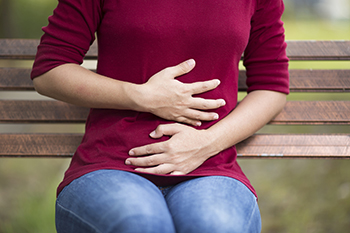 Someone clutching their own stomach