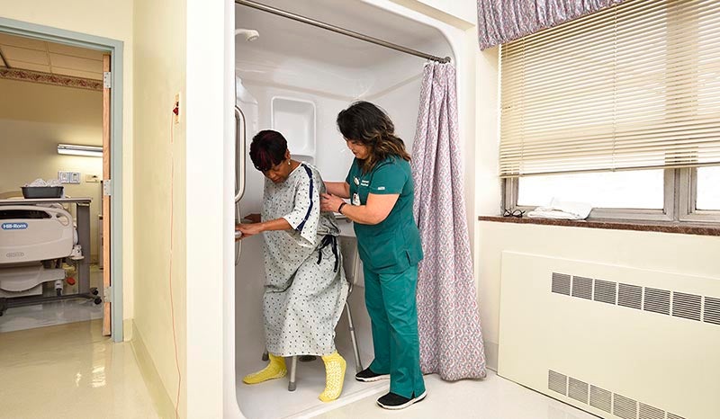 A nurse helping a patient into the shower