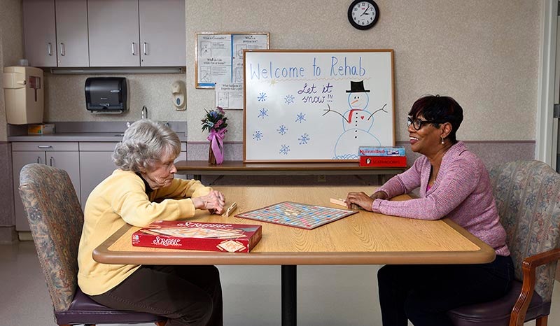 A patient speaking with someone at a kitchen table